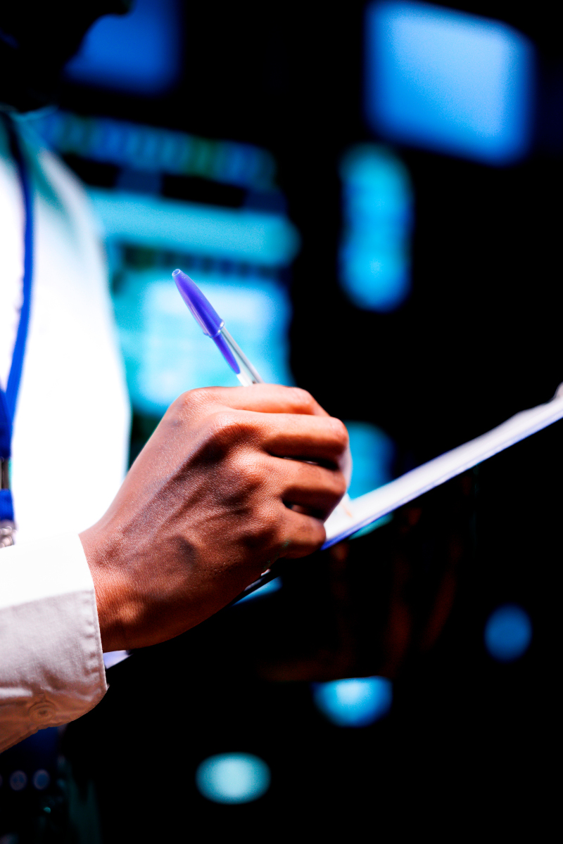 Close up shot of diligent engineer equipped with maintenance checklist in data center. Admin carefully examining critical systems in high tech establishment searching for irregularities